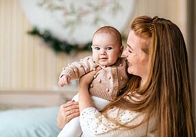 Frau mit Baby auf dem Arm.