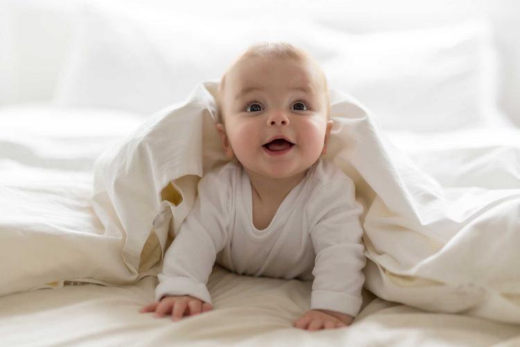 Bildnachweis: © stock.adobe.com / Louis-Paul Photo Baby liegt auf dem Bauch und stuetzt sich mit den Armen ab