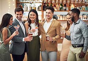 Gruppe mit alkoholischen Getränken in der Hand in einer Bar