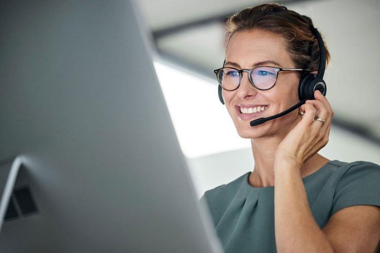 Frau mit Headset beantwortet Kundenanfragen