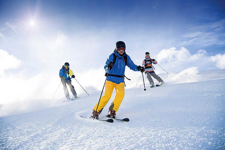 Drei Skifahrer auf der Skipiste