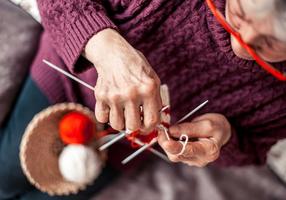 Frau mit Rheuma in den Händen strickt.