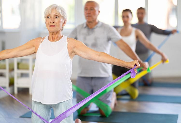 Bildnachweis: © stock.adobe.com / JackF Rücken stärken mit dem Theraband, Gruppe im Fitnessstudio