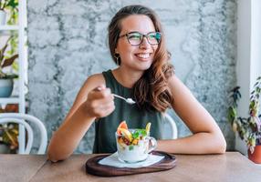 Junge Frau isst einen Fruchtsalat