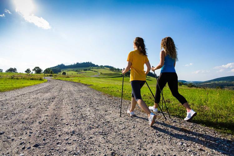 Zwei junge Frauen beim Nordic Walking