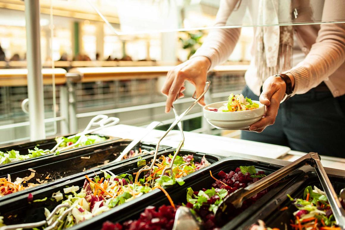 Bildnachweis: © stock.adobe.com / Robert Poorten Frauenhände bedienen sich am Salatbuffet in einer Kantine