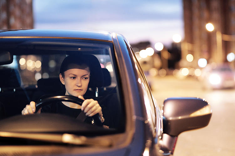 Eine Frau nachts am Steuer eines Autos.