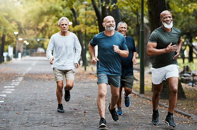 Gruppe Männer joggt gemeinsam im Park