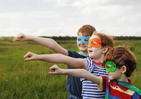 Kinder mit Masken spielen Supeerhelden