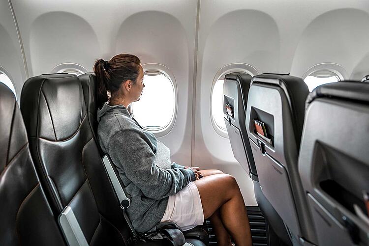 Reisethrombose: Frau sitzt im Flugzeug