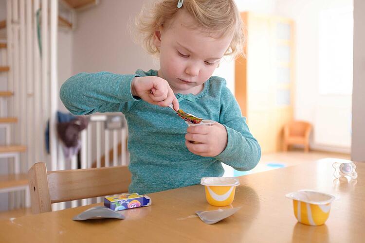 Mädchen isst einen Joghurt