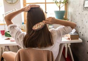 Frau kämmt ihre langen Haare