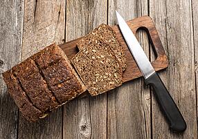 Aufgeschnittenes Vollkornbrot auf einem Holzbrett