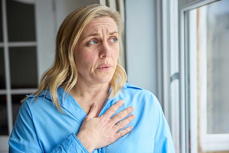 Herzinfarkt bei Frauen: Frau greift sich ans Herz