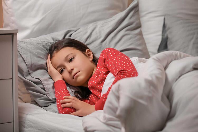 Schlafstörungen bei Kindern: Mädchen liegt schlaflos im Bett
