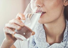 Frau trinkt ein Glas Wasser