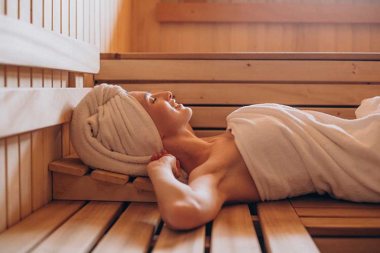 Frau liegt entspannt in der Sauna
