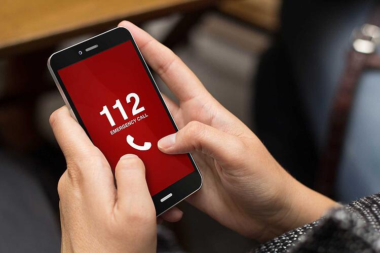 Frau wählt Notrufnummer 112 auf dem Smartphone