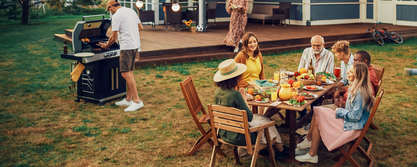 Familie, Freunde und Nachbarn grillen und essen gemeinsam